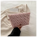 Detailed close-up of pink heart-quilted fabric texture and golden zipper on makeup bag - Pink