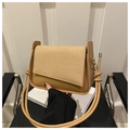 Detalle de bolso retro caqui con solapa de textura ondulada y alas laterales únicas - Caqui