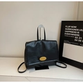Close-up of black retro leather backpack featuring a stylish oval gold metal twist lock - Black