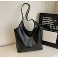 Detalle de un bolso tote grande de cuero sintético negro con textura minimalista urbana - Negro