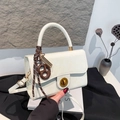 White faux leather crossbody bag with golden twist lock and twisted charm detail - White With Pendant