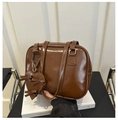 Detail of glossy brown faux leather shoulder bag with a heart charm and ribbon decor - Brown