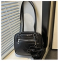 Detail of glossy black leather shoulder bag with silver zipper and heart bow charm - Black