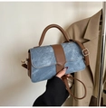 Detail of blue denim and brown leather stitching on a mini crossbody bag with gold hardware - Blue Without Charm