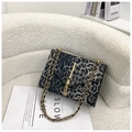 Luipaardprint crossbody tas met gouden ketting en kwastje op een witte bankstel - Grijs Stijl 2