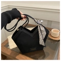 Detalle de bolso tote negro con corte en V, asa de seda y etiqueta decorativa - Negro