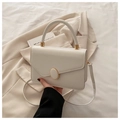 Detalle del bolso bandolera de cuero crema con hebilla dorada y asa de transporte - Blanco