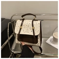 Detailaufnahme eines Polka-Dot-Rucksacks mit brauner Klappe und Magnetverschluss - Weiß