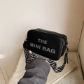 Black mini camera bag with THE MINI BAG print and geometric wide shoulder strap - Black