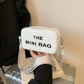 White mini camera bag in pebble leather with bold lettering and patterned wide strap - White