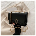 Detail of black glossy crossbody bag with gold chunky chain strap and metal clasp lock - Black