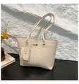 Gros plan du sac cabas beige grainé avec une mini pochette et une plaque logo dorée - Blanc Cassé