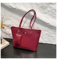 Détail d'un sac cabas bordeaux en cuir litchi avec ornements dorés et petite pochette - Rouge