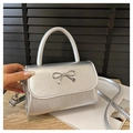 Detail der silbernen Mini-Handtasche mit Metallstruktur, Schleife und Tragegriff - Silber