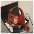 Deep red crescent shoulder bag in glossy leather with gold hardware and woven pendant - Red (With Pendant)