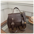 Detail of vintage dark brown faux leather backpack with embossed logo and decorative charms - With Charm / Coffee