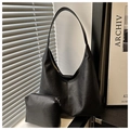 Détail de la texture cuir grainé noir sur un sac hobo minimaliste avec sa pochette - Noir