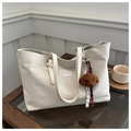 Dettaglio di una borsa tote oversize bianco crema con ciondolo a forma di cane di peluche - Con Ciondolo / Bianco