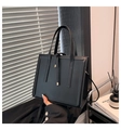 Détail d'un sac cabas rectangulaire noir minimaliste avec poignées dans un décor moderne - Noir