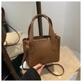 Close-up of caramel brown pebble leather bucket bag with top handles and logo detail - Coffee Without Pendant