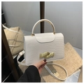 Detail of white crocodile pattern handbag with gold hardware and stylish handle - White