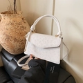 White faux leather crossbody bag with embossed floral texture and knotted top handle - White