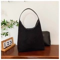 Détail du sac cabas en cuir mat noir et de sa pochette interne sur une table en bois - Noir
