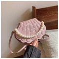 Detalle de bolso de concha rosa con purpurina, asa de perlas y correa brillante a la moda - Rosa