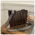 Deep brown quilted leather tote bag with houndstooth strap on a wooden table setup - Coffee