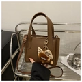 Brown litchi grain leather bucket bag with plush charm and fashion logo imprint - Coffee with Pendant