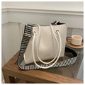 Detail view of cream tote bag featuring diamond quilt stitching and houndstooth strap - Beige