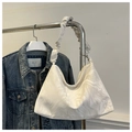 Detail view of stylish marble pattern handbag featuring a soft pleated ruched shoulder strap - White