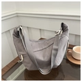 Dettaglio della borsa a mezzaluna in nylon grigio con tracolla regolabile sul tavolo - Grigio