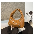 Close-up of caramel hobo bag with large silver stud accents and knotted handle detail - Brown