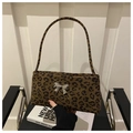 Detailopname van luipaardprint baguette tas met een zilveren metalen vlinder - koffiekleur