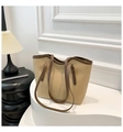 Primer plano de bolso tote beige con correas marrones en un soporte blanco elegante - Caqui