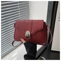 Detail shot of vintage dark red crossbody bag with silver rotating metal lock and fine strap - Red