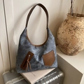 Retro denim shopper van blauwe stof met bruine leren hengsels op een vintage koffer - Blauw