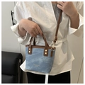 Détail du sac seau en denim bicolore avec clous dorés et anses en cuir marron - Bleu Sans Pendentif