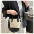 Détail du sac seau bicolore montrant la texture de toile et les poignées en cuir noir - Noir & Khaki Sans Charme
