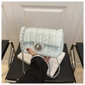 Close-up of light blue quilted crossbody bag featuring silver chain and twist-lock - Blue