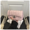 Close-up of pink quilted crossbody bag with silver twist lock and chain strap detail - Pink