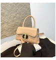 Detalle del bolso beige de piel con cierre de metal en T y asa redonda elegante - Caqui