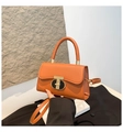 Detail of orange square bag with golden T-lock clasp and round top handle - Brown