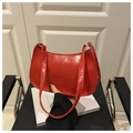 Detail of red faux crocodile leather shoulder bag with gold hardware and curved strap - Red
