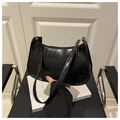 Detail of black faux leather underarm bag with embossed crocodile texture and gold hardware - Black