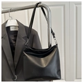 Detalle de correa ajustable y hebilla plateada en bolso tote negro de estilo minimal - Negro