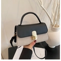 Detail einer Handtasche aus Kontrastleder und Webstoff mit goldenem Verschluss - Schwarz