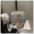 Macro view of silver quilted crossbody bag featuring a metal butterfly clasp and wide strap - Silver