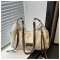 Dettaglio borsa tote color crema con tessuto testurizzato, manici in pelle e etichetta - Senza Ciondolo / Bianco